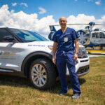 Dr. P.S. Martin in front of quick response vehicle & helicopter